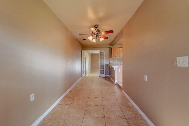 corridor with light tile patterned floors and french doors