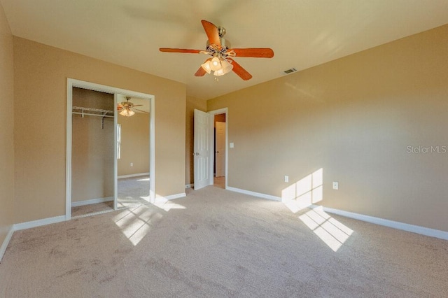 unfurnished bedroom featuring ceiling fan, a closet, and light carpet