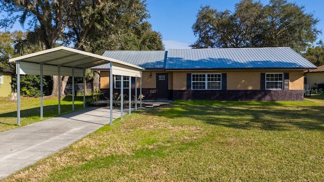 single story home featuring a detached carport, stucco siding, metal roof, and a front lawn