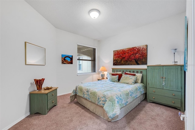 bedroom with light colored carpet and a textured ceiling