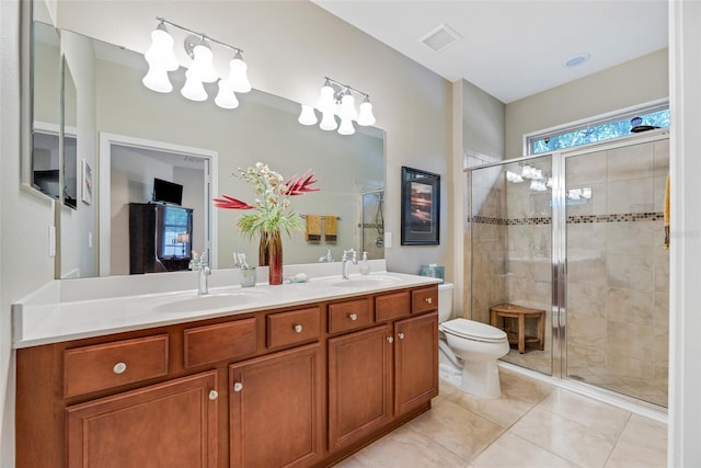 bathroom featuring toilet, vanity, a shower with door, and tile patterned floors