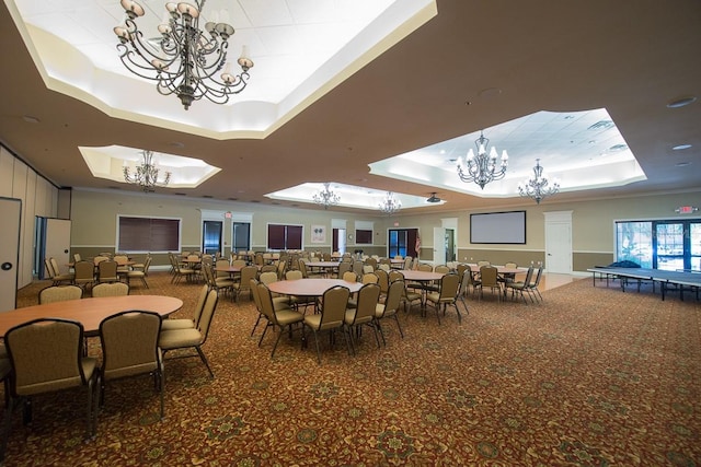 carpeted dining space featuring ornamental molding and a tray ceiling