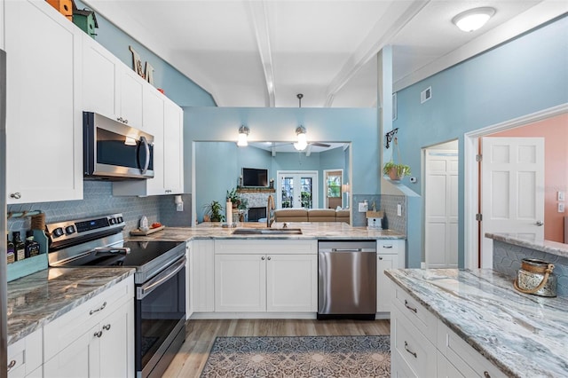 kitchen featuring sink, white cabinets, appliances with stainless steel finishes, and tasteful backsplash