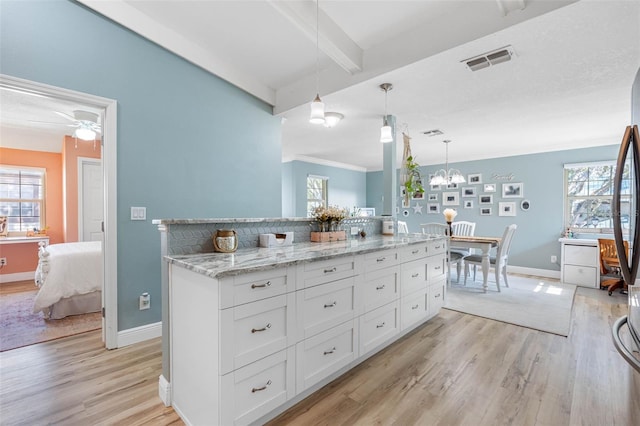 kitchen featuring decorative light fixtures, light hardwood / wood-style floors, white cabinets, and beam ceiling