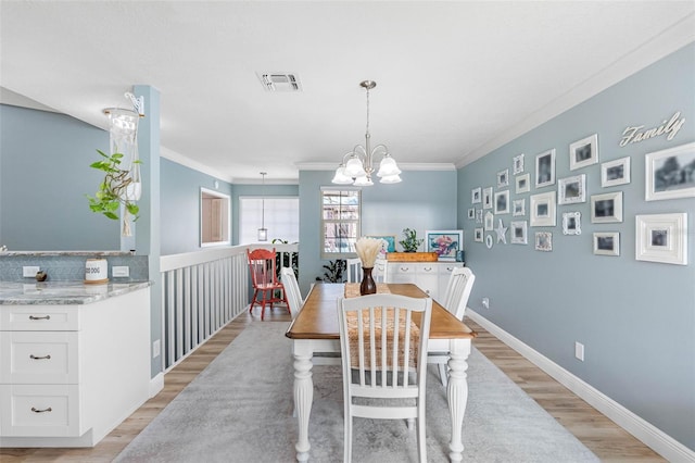 dining room featuring an inviting chandelier, crown molding, and light hardwood / wood-style floors