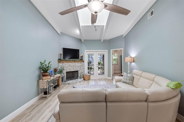 living room with ceiling fan, lofted ceiling with beams, french doors, and light hardwood / wood-style flooring