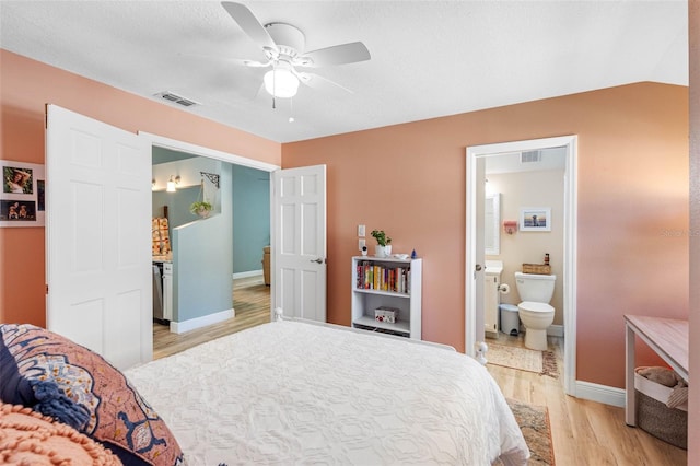 bedroom featuring light wood-type flooring, ceiling fan, ensuite bathroom, and lofted ceiling