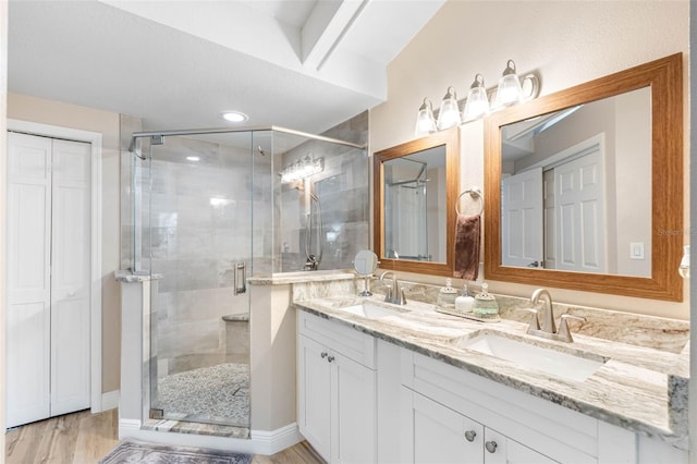 bathroom with wood-type flooring, walk in shower, and vanity