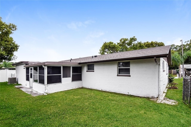 rear view of property with a yard, a sunroom, and central air condition unit