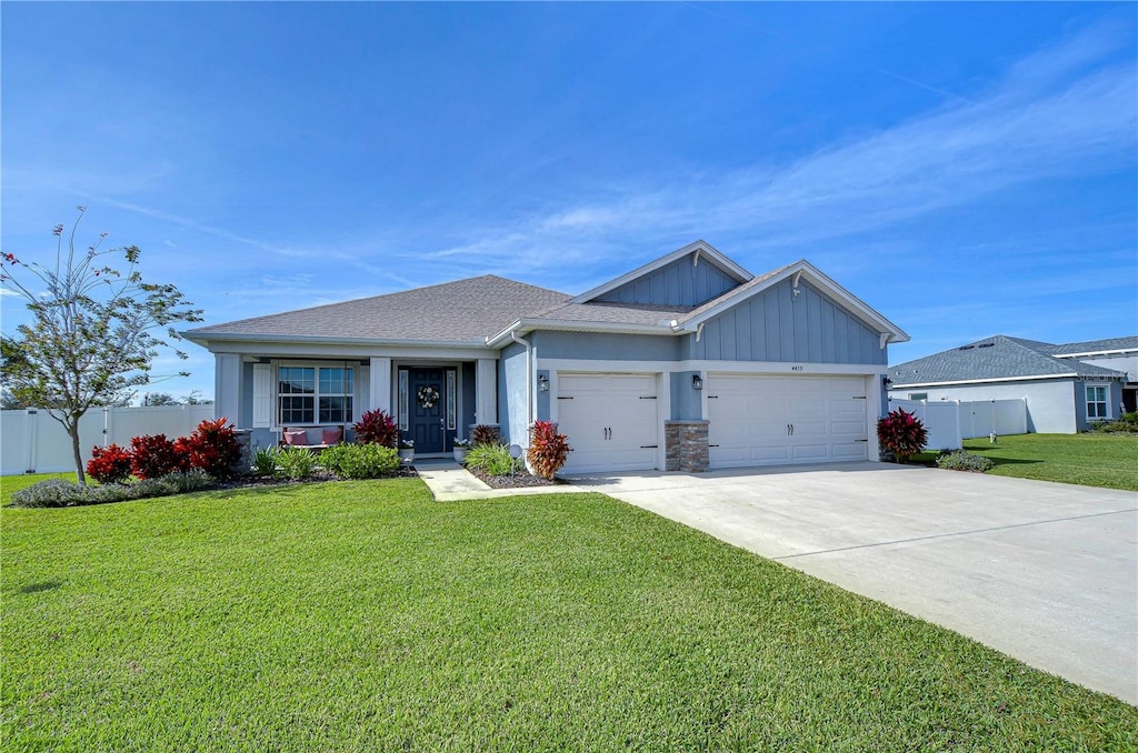 craftsman inspired home featuring a garage and a front lawn