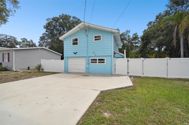 rear view of property featuring a lawn and a garage