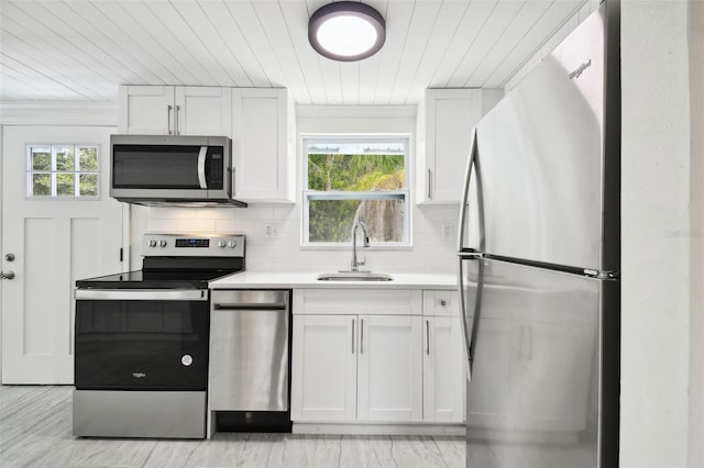 kitchen featuring plenty of natural light, stainless steel appliances, white cabinetry, and sink