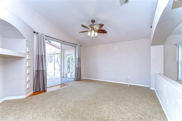 unfurnished living room with ceiling fan, lofted ceiling, carpet floors, and a textured ceiling