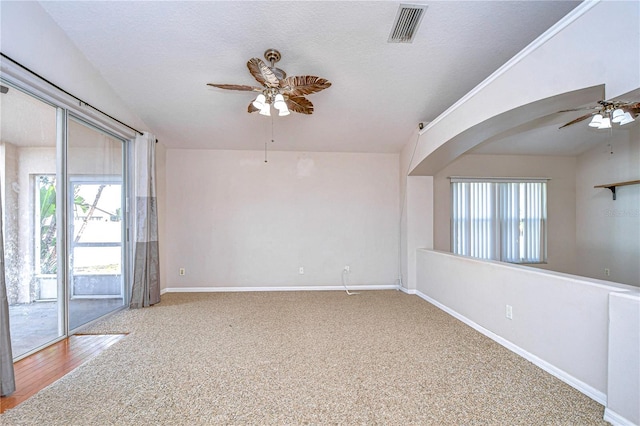 carpeted spare room featuring ceiling fan, plenty of natural light, and a textured ceiling