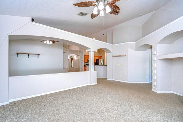 empty room with ceiling fan, a textured ceiling, and a towering ceiling