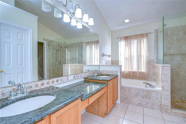 bathroom featuring vanity, vaulted ceiling, shower with separate bathtub, and tile patterned floors