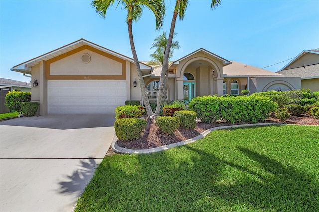 single story home featuring a front lawn, driveway, an attached garage, and stucco siding