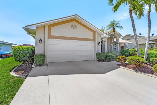 view of front of property featuring an attached garage, concrete driveway, and stucco siding