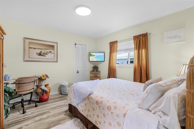 bedroom featuring a closet, baseboards, and wood finished floors