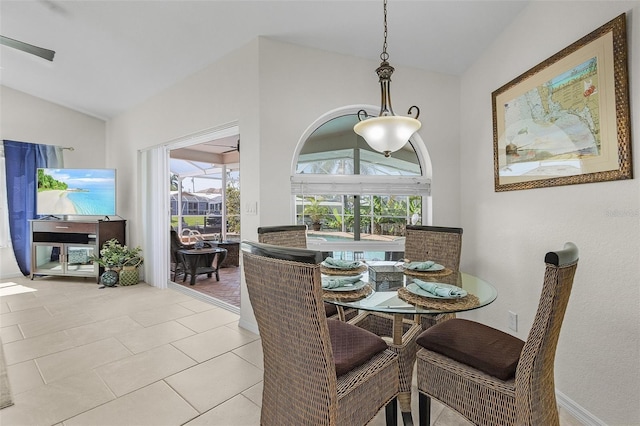 dining space featuring light tile patterned flooring and vaulted ceiling