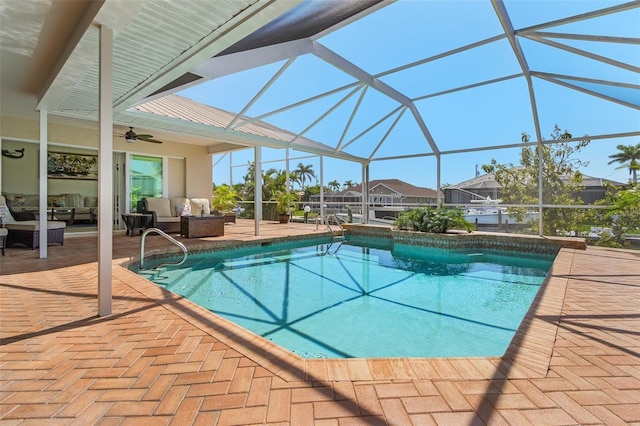 outdoor pool with a ceiling fan, glass enclosure, a patio area, and outdoor lounge area