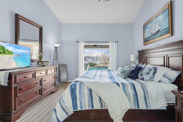 bedroom featuring lofted ceiling, baseboards, and access to exterior