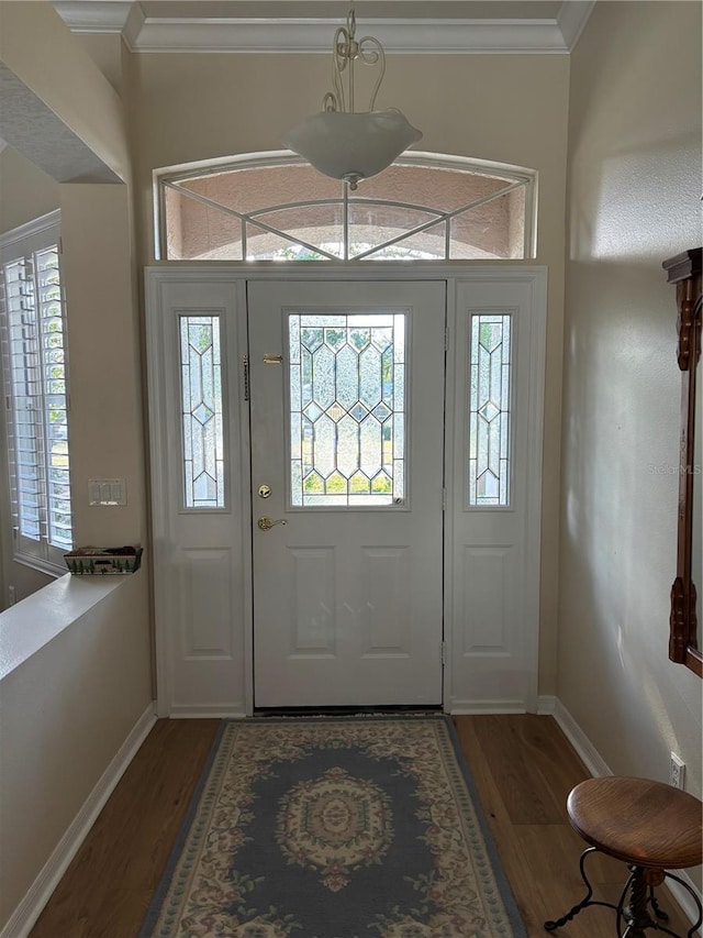 entryway featuring crown molding and dark wood-type flooring