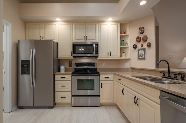 kitchen featuring appliances with stainless steel finishes, sink, and cream cabinetry