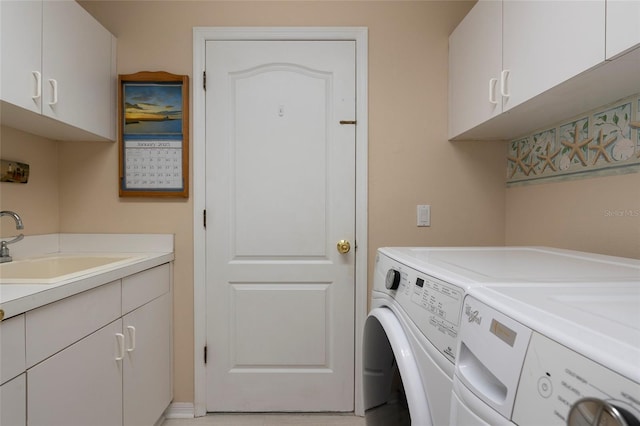 clothes washing area with cabinets, separate washer and dryer, and sink