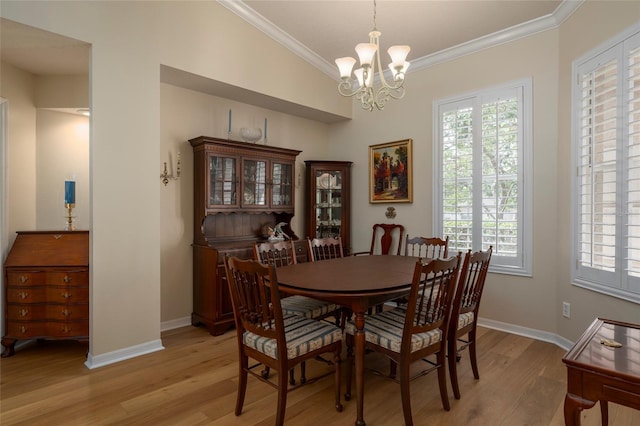 dining space featuring vaulted ceiling, ornamental molding, a chandelier, and light hardwood / wood-style floors