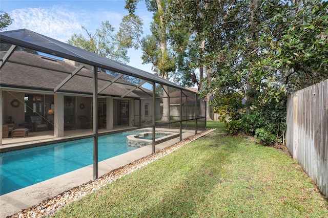 view of pool featuring a yard, a patio area, glass enclosure, and an in ground hot tub