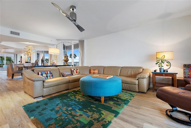 living room featuring ceiling fan, a wealth of natural light, and light hardwood / wood-style flooring