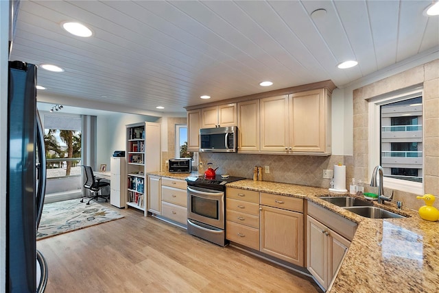 kitchen featuring light wood-type flooring, appliances with stainless steel finishes, light brown cabinets, and sink