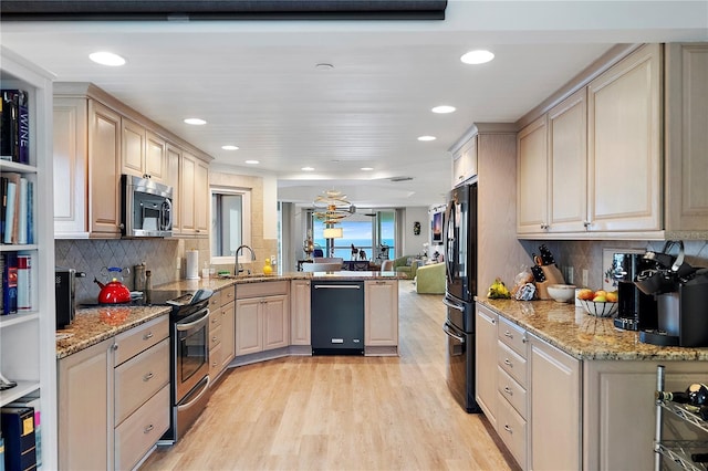 kitchen featuring light stone countertops, black appliances, tasteful backsplash, light hardwood / wood-style floors, and sink