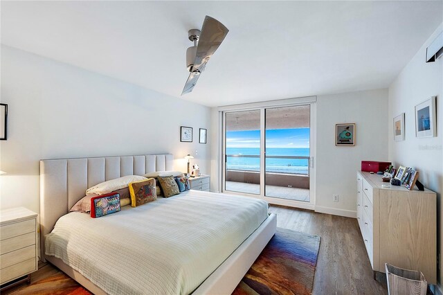 bedroom with ceiling fan, dark hardwood / wood-style flooring, a water view, and access to outside