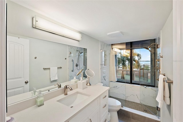 bathroom featuring toilet, a tile shower, and vanity