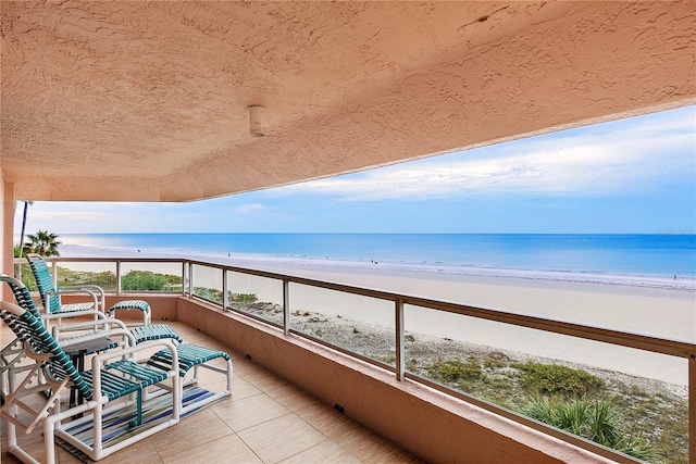 balcony featuring a water view and a beach view