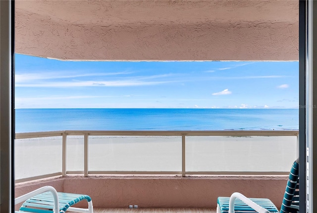 balcony with a water view and a beach view