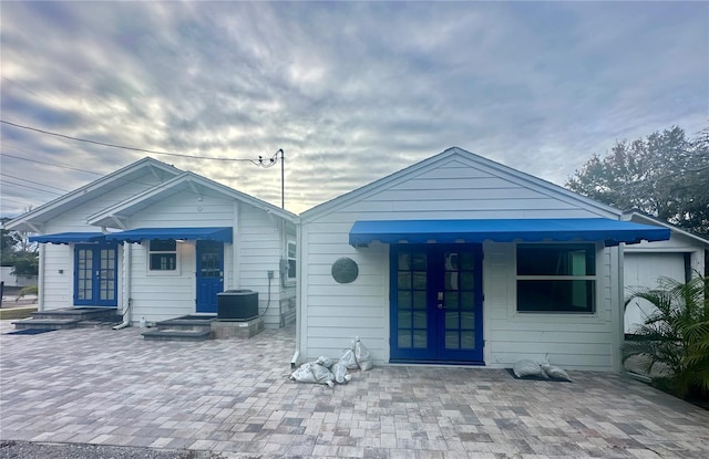 rear view of house with central AC and french doors