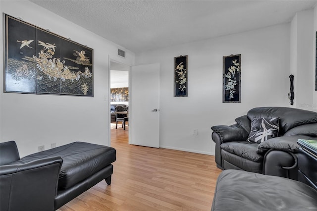 living room featuring a textured ceiling and hardwood / wood-style flooring