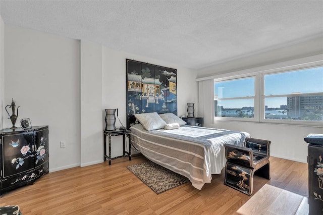 bedroom featuring a textured ceiling and hardwood / wood-style floors