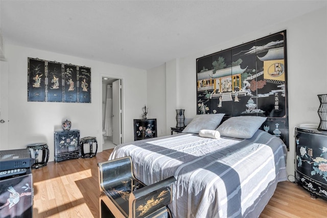 bedroom featuring wood-type flooring and connected bathroom