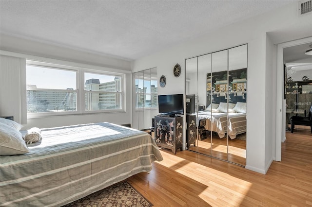 bedroom with light hardwood / wood-style floors and a textured ceiling