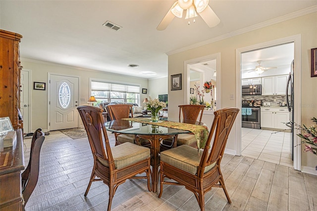 dining area with ceiling fan, ornamental molding, and light wood-type flooring