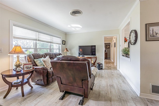 living room with ornamental molding and light hardwood / wood-style floors