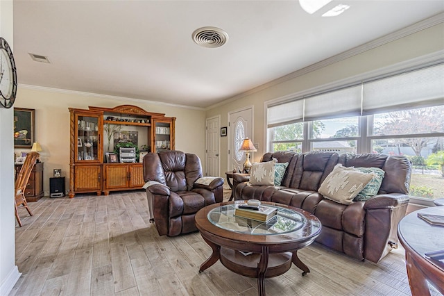 living room featuring crown molding, a wealth of natural light, and light hardwood / wood-style flooring