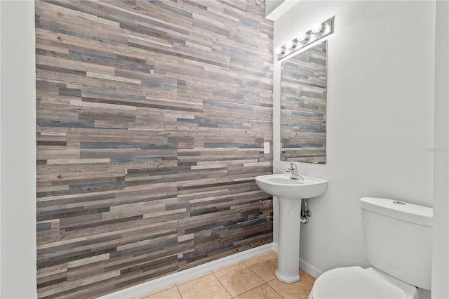 bathroom featuring toilet, tile patterned flooring, and wooden walls