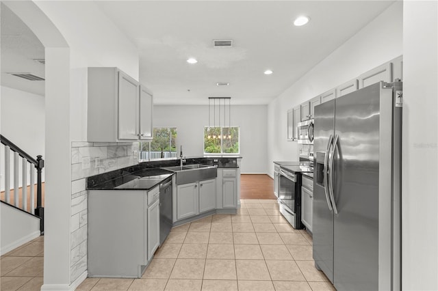 kitchen featuring stainless steel appliances, sink, hanging light fixtures, light tile patterned floors, and gray cabinetry