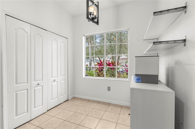 laundry room featuring light tile patterned flooring, a healthy amount of sunlight, and washer / clothes dryer