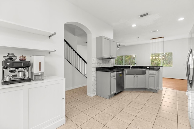 kitchen featuring dishwasher, sink, hanging light fixtures, light tile patterned floors, and gray cabinetry